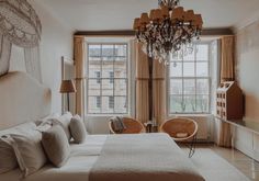 a bedroom with a chandelier hanging from the ceiling next to a large bed