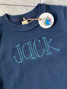 a close up of a t shirt with the word jock on it and a badge