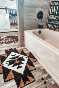 a bathroom with a bathtub and rugs on the floor