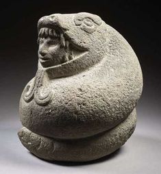 a stone sculpture with a woman's head on it, sitting in front of a dark background