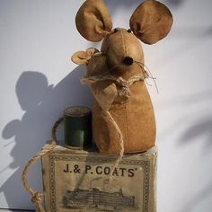 a stuffed mouse sitting on top of a box