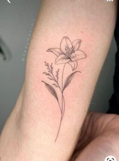 a small flower tattoo on the arm