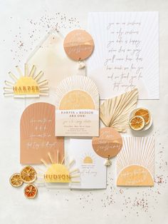 the wedding stationery is laid out on top of each other, including orange slices