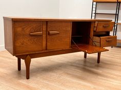 a wooden cabinet with drawers and a bench in the middle on a hard wood floor