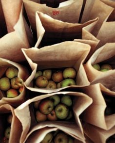 several bags filled with apples sitting on top of each other