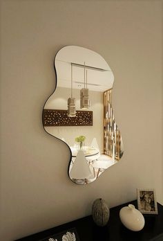 a mirror that is on the side of a wall next to a vase with flowers