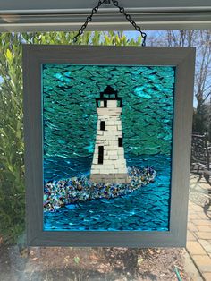 this is an image of a lighthouse made out of sea glass in the window sill