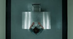 a person standing in front of a urinal with their hands on the ground and feet up