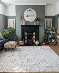 a living room filled with furniture and a fire place next to a rug on top of a hard wood floor