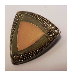 Beautiful enameled brooch in a classic 40s or 50s style. A double triangle with rounded edges in almond green and matte gold or pinkish beige tones framed on three sides by a throw of transparent rhinestones A very fine gold dusting over the entire surface gives a discreet and elegant luminosity Marked France on the back followed by a logo that I was unable to identify Safety closure Dimensions 35/35 millimeters Unique, antique, vintage piece in perfect condition. Free delivery with code DORA194 Pinkish Beige, Double Triangle, Jewelry Brooch, Beige Tones, Vintage Fine Jewelry, 50s Style, Tie Tack, Tie Accessories, Gold Enamel