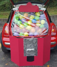 a red car with its trunk open filled with candy