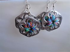 there is a pair of silver earrings with multicolored yarn on it and two hooks hanging from them