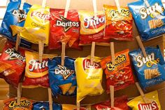 several bags of chips are hanging on the wall with toothpicks stuck to them