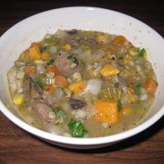 a white bowl filled with soup on top of a wooden table