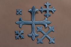 a cross made out of blue clay on a brown surface with other crosses in the background