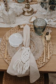 a place setting with napkins, plates and silverware on a wicker table