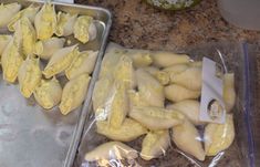 two pans filled with peeled bananas on top of a counter next to each other