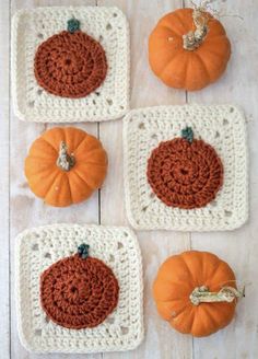 four crocheted pumpkins are sitting on the table