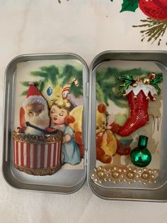 two tins filled with christmas decorations on top of a table