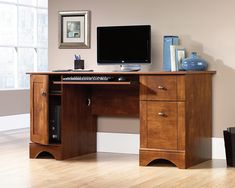 a computer desk with a monitor, keyboard and mouse