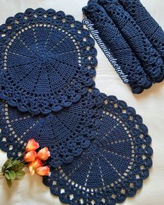 two crocheted doily on a bed with flowers