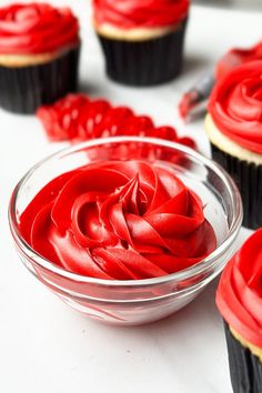 cupcakes with red frosting in a bowl on a table