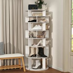 there is a white shelf with many pairs of shoes on it and a chair next to it