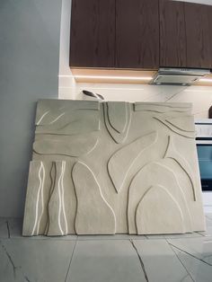 a kitchen area with a stove, oven and counter top covered in white marble tiles