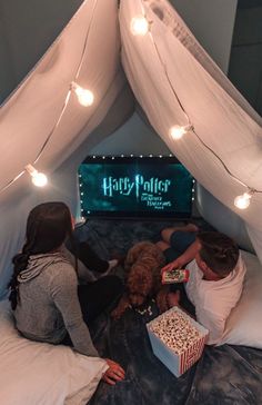 two people sitting on a bed with a dog in front of a harry potter sign