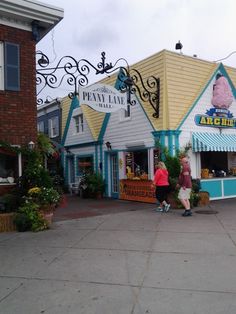 two people are walking in front of a store