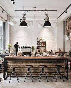 an industrial style kitchen island with stools and lights hanging from it's ceiling