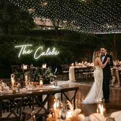 a bride and groom sharing a first dance at their wedding reception with the words'the cababs'lit up in the background