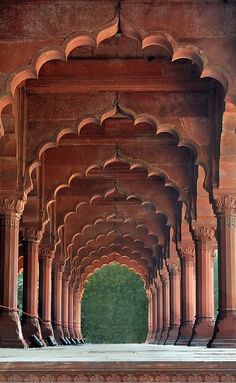 an archway in the middle of a building with columns and arches on both sides, leading into