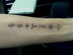 a person with a tattoo on their arm that has symbols in different sizes and colors