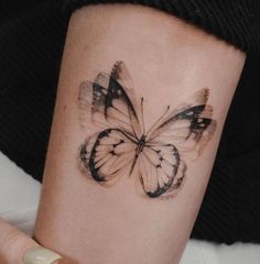 a woman's arm with a butterfly tattoo on it