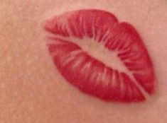 a close up shot of a red lip with the tip of a circle shaped like a kiss