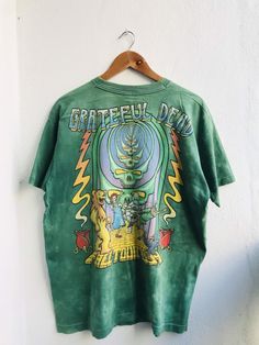 Vintage Grateful Dead Follow The Golden Road Fall Tour 1994 Rock Band T-Shirt. One multipurpose item of clothing for the upper body is a shirt. It is an essential article of apparel since it is available in an enormous array of hues, patterns, and materials. In addition to characteristics like sleeves, a collar, and buttons on the front, shirts are available in an array of designs and styles to accommodate a wide range of preferences and situations. Not only is wearing a shirt a fantastic option Psych Rock, Grateful Dead, Rock Band, Stylish Shirts, Upper Body, Rock Bands, Fashion Games, Men Short Sleeve, The Golden