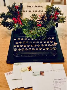 an old fashioned typewriter sitting on top of a table next to some christmas decorations