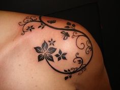 a woman's shoulder tattoo with flowers on it