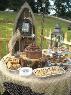 a table topped with lots of desserts on top of a wooden table next to a fence