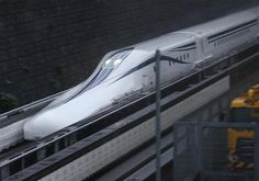 a white train traveling down tracks next to a loading platform