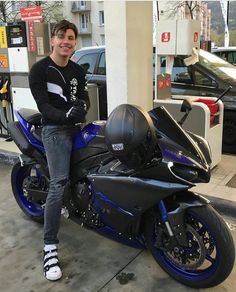 a man sitting on top of a blue motorcycle