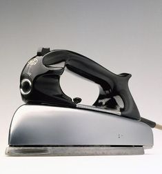 a black and silver iron on a white surface