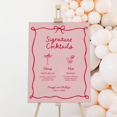 a pink sign sitting on top of a wooden easel next to white and red balloons