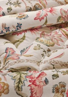 an upholstered floral print bed spread with white sheets and matching pillowcases