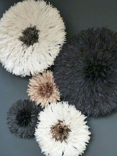 four black and white rugs are arranged on a gray surface, with one large flower in the center