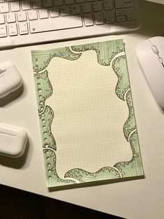 a notepad sitting on top of a desk next to a computer mouse and keyboard