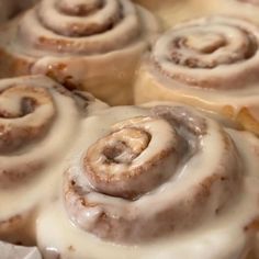 cinnamon rolls with icing sitting in a pan