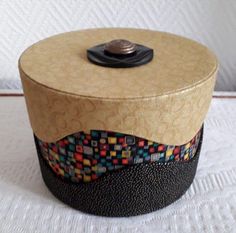 a small round box sitting on top of a white table