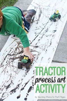 a young boy playing with toy trucks on the ground next to a sign that says tractor process art activity